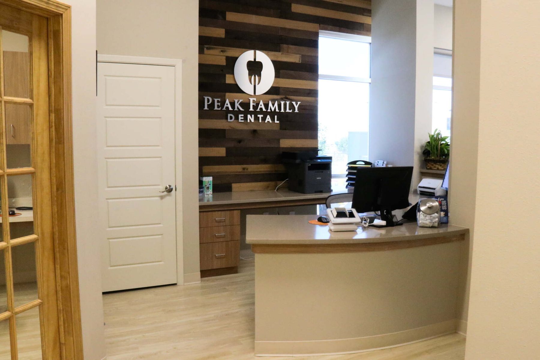 Reception desk and logo wall at Peak Family Dental